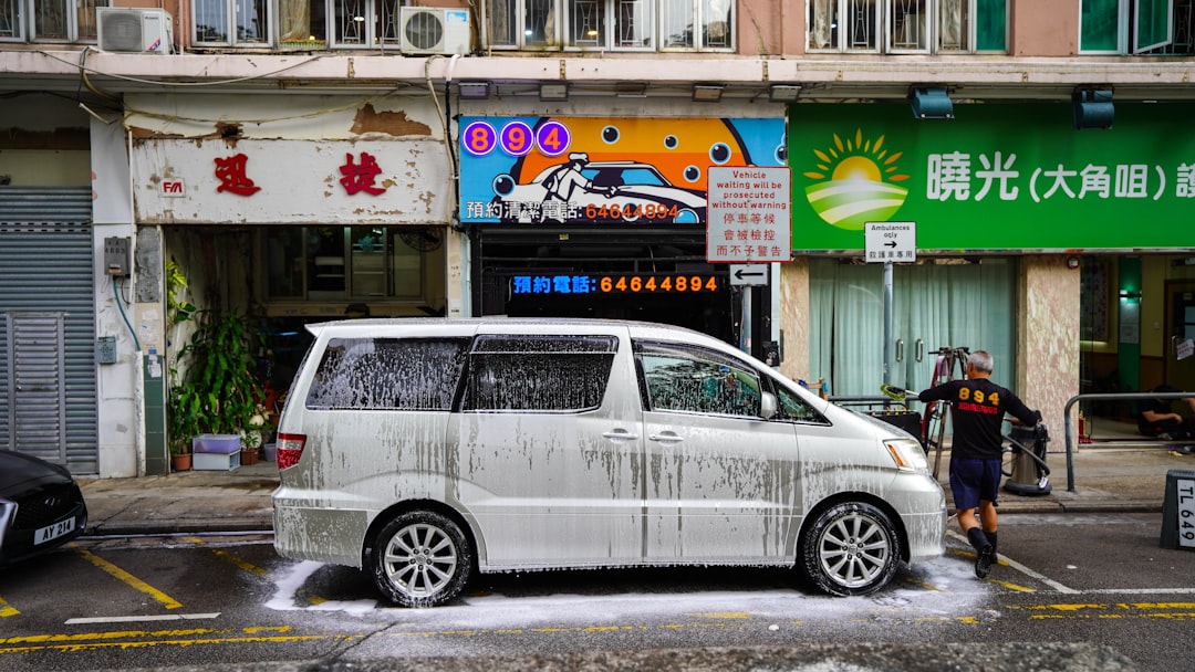 a-white-van-parked-in-front-of-a-building-fyi0vp5pgl4