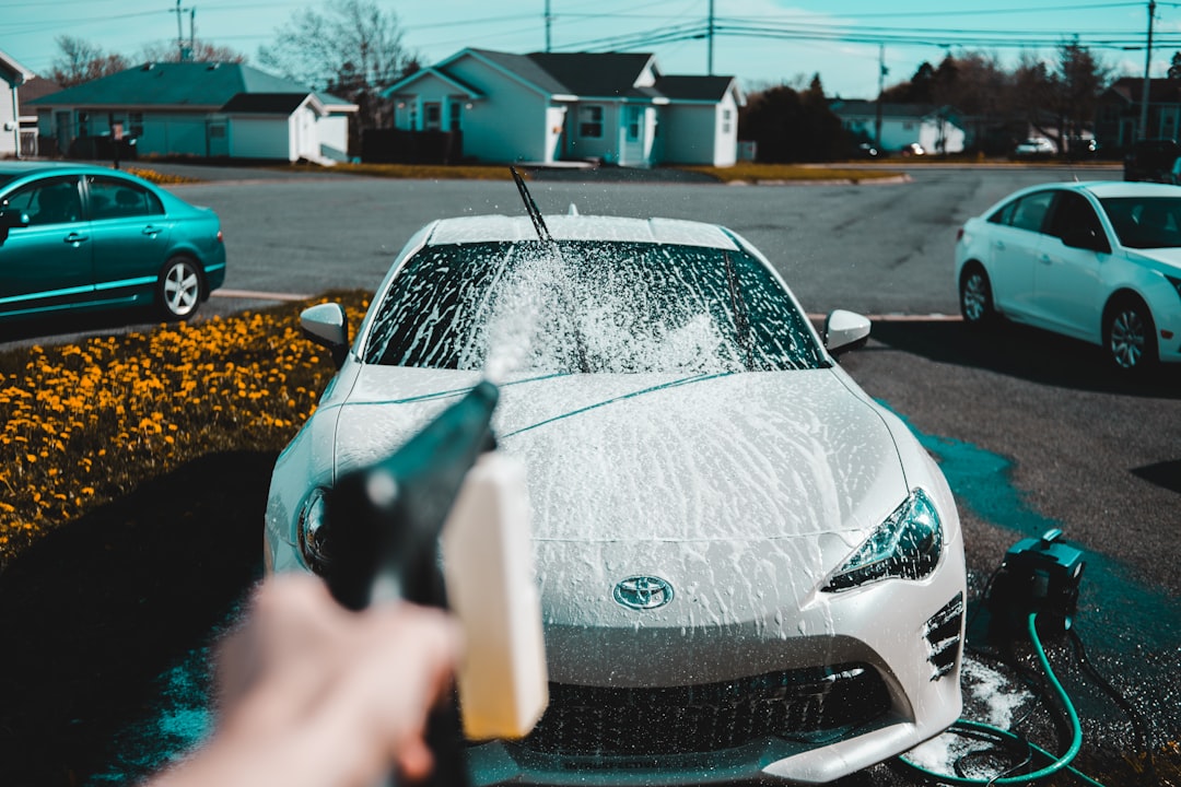 person-spraying-water-on-vehicle-ifq8q3iay5u